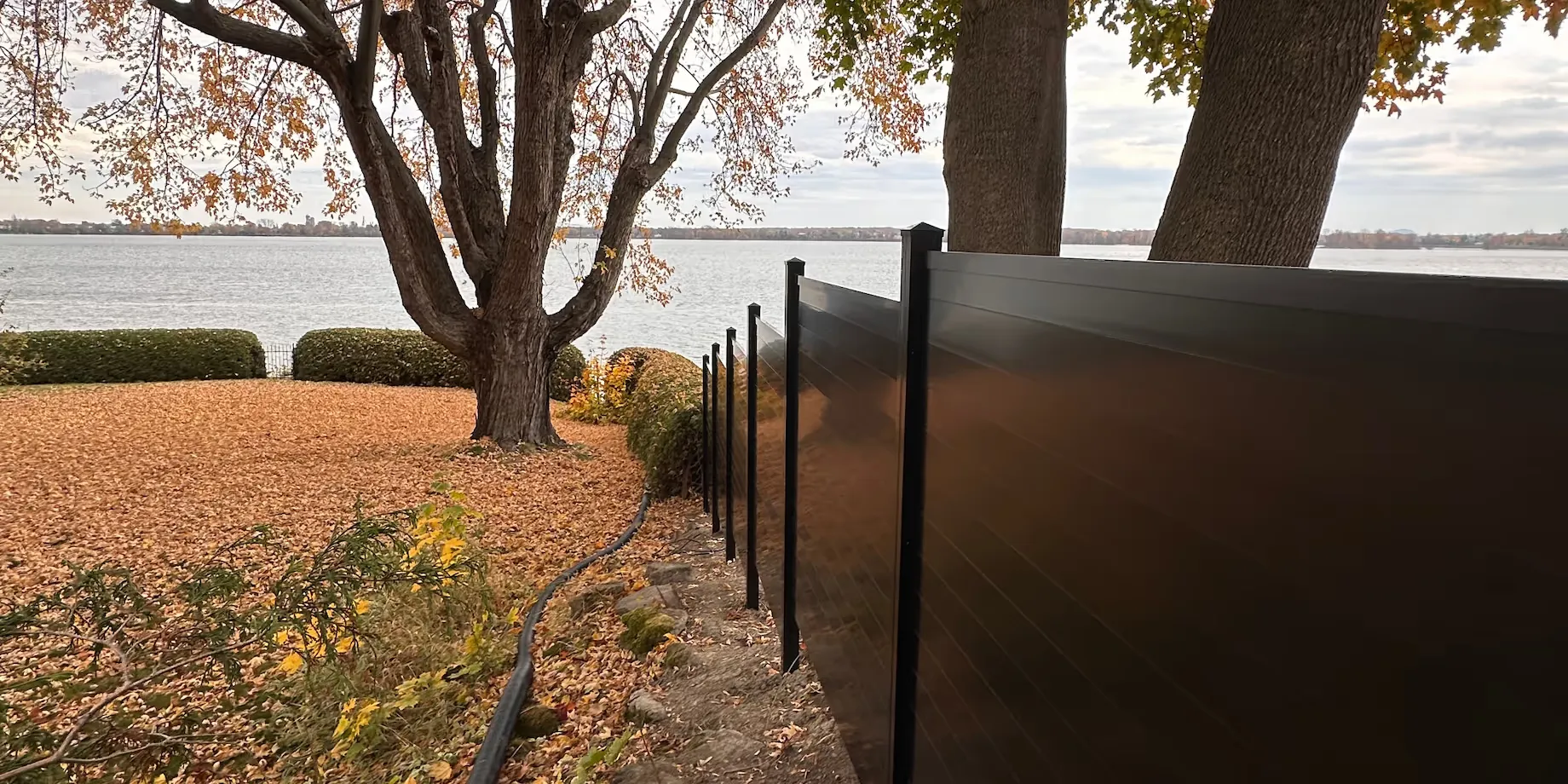 Clôture zen en aluminium gris avec lignes horizontales devant une maison