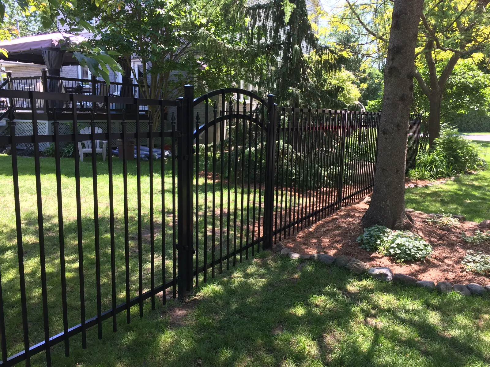 Porte arquée de clôture ornementale en aluminium avec arbres matures