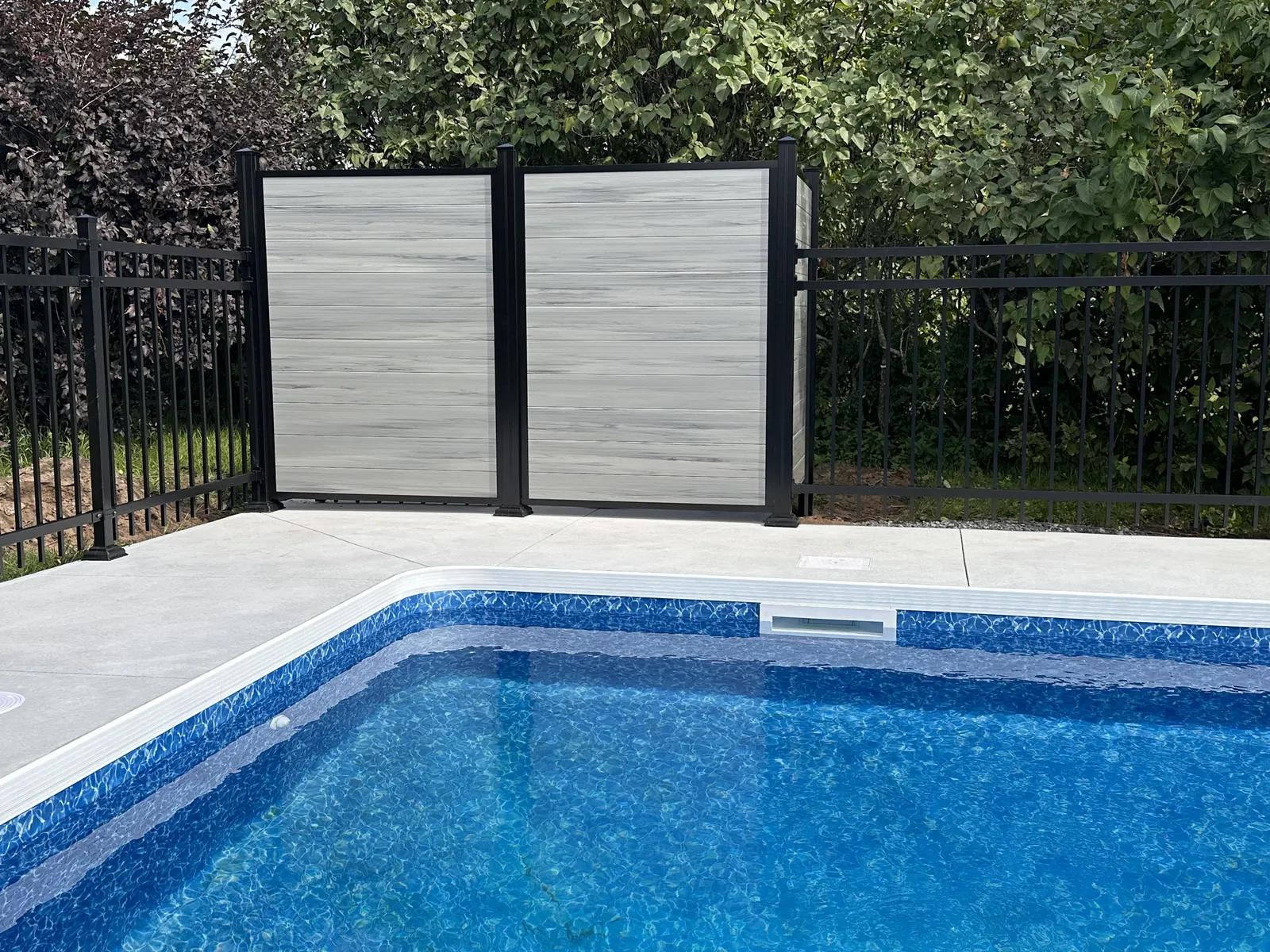 Panneaux de PVC gris à côté d'une piscine creusée